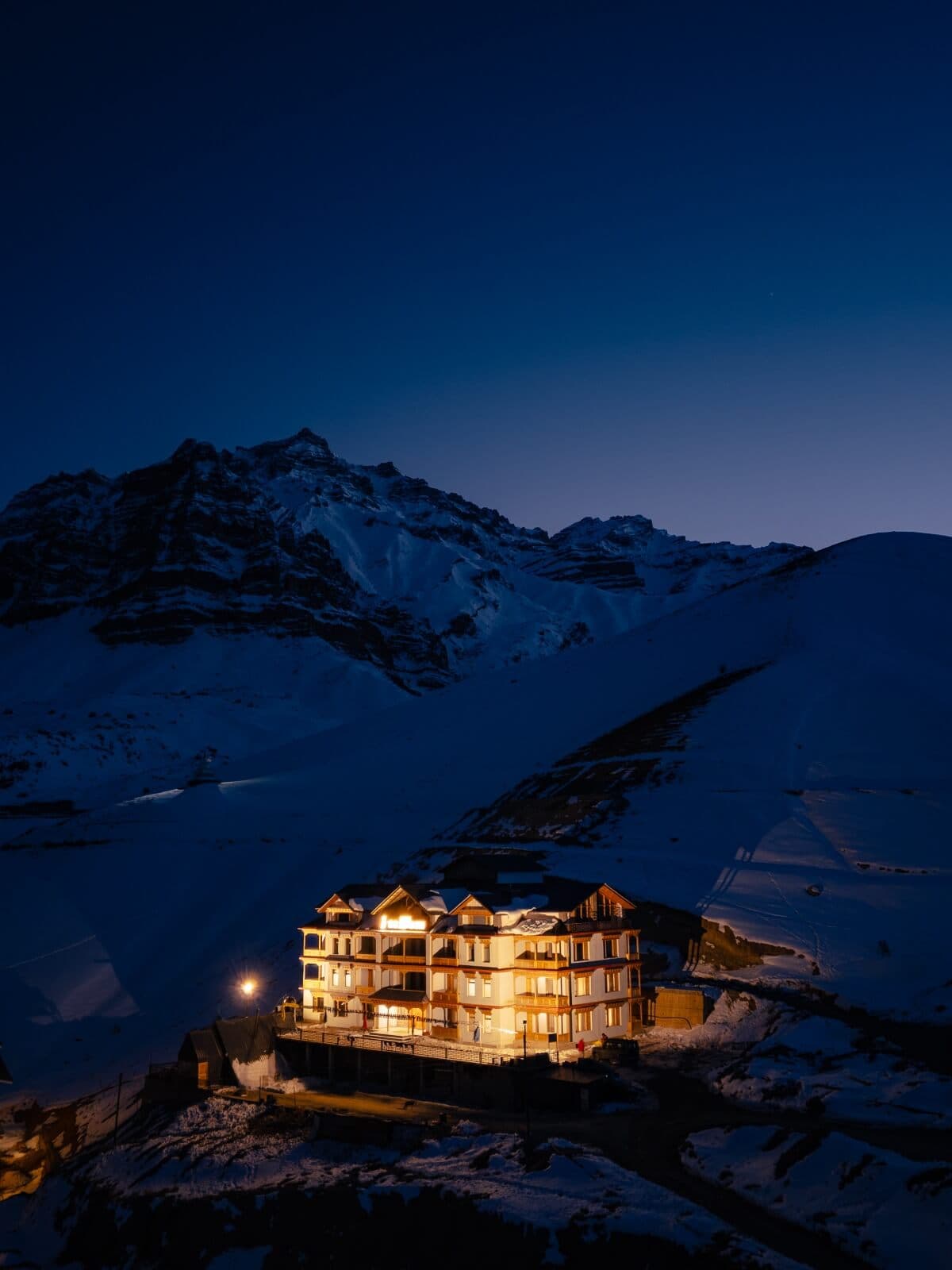 The Zambori lit up at night against the snow-capped Spiti mountains